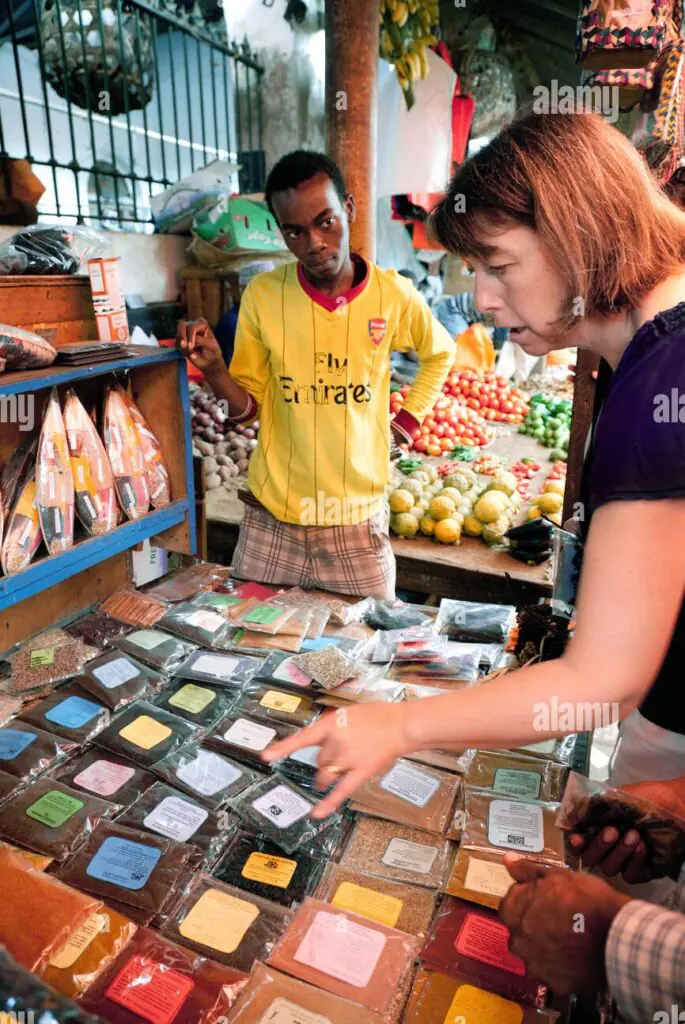 a woman buying spices in the darajani market stone town zanzibar africa CX4M20 e1723879275964
