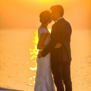 How to plan a beach wedding in Zanzibar 4 Captivating moment of a couple sharing a kiss during a beach sunset wedding, exuding romance.