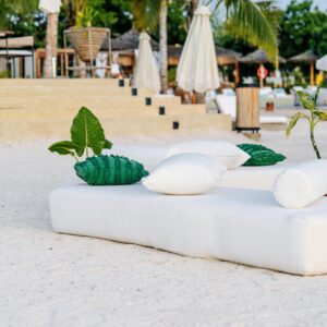 How to plan a beach wedding in Zanzibar 6 Relaxing tropical beach scene in Zanzibar with lounge cushions and palm trees.