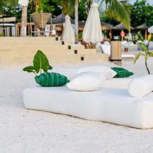 How to plan a beach wedding in Zanzibar 6 Relaxing tropical beach scene in Zanzibar with lounge cushions and palm trees.