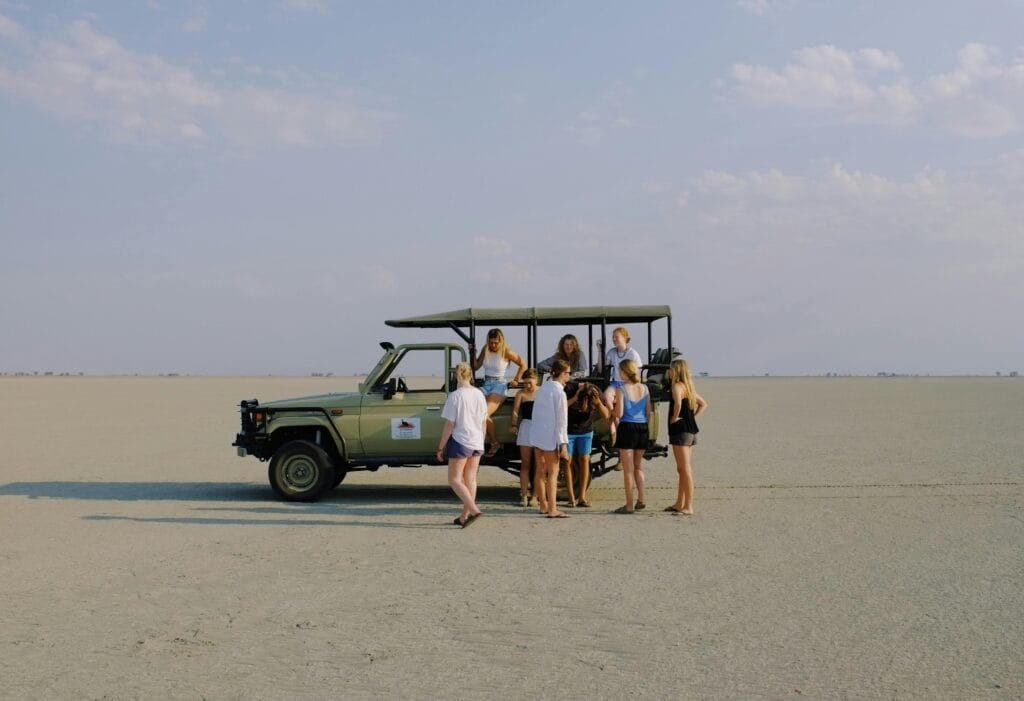 A Group of People Standing near a Vehicle in the Desert
