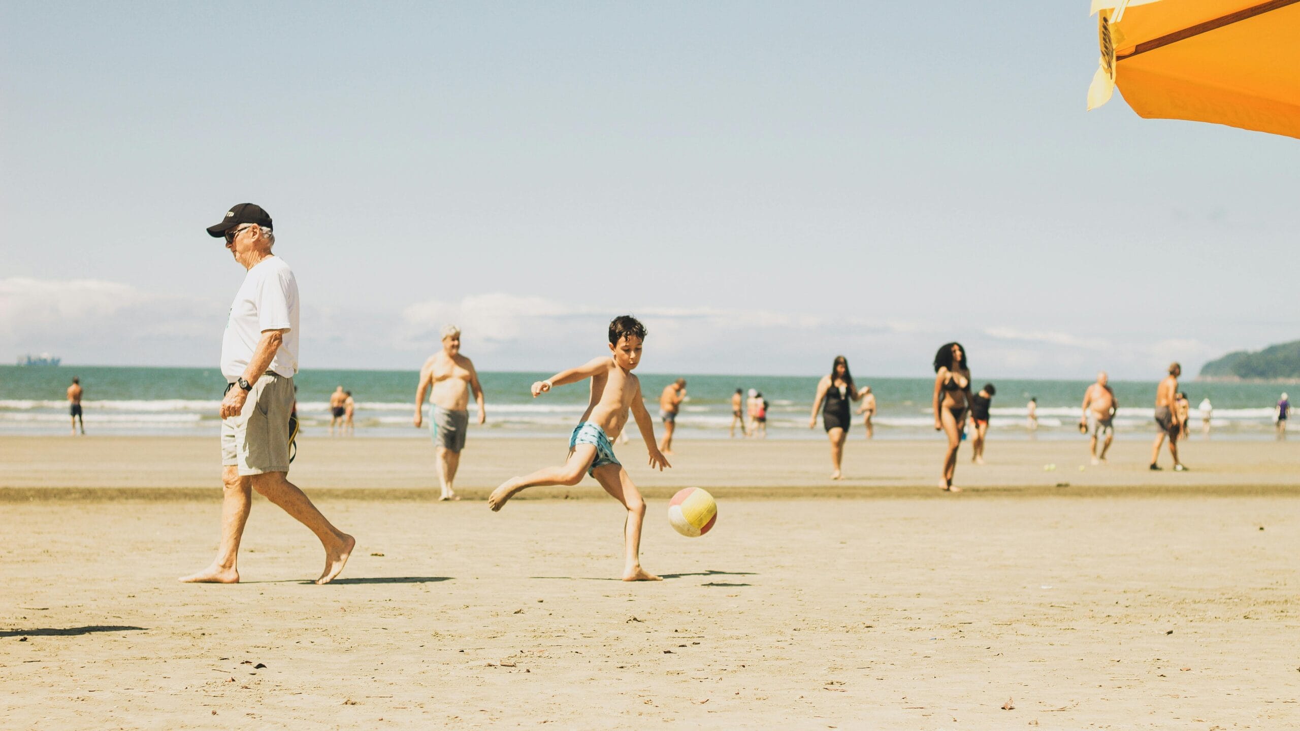 A lively beach scene in Brazil with people enjoying a sunny day by the ocean.