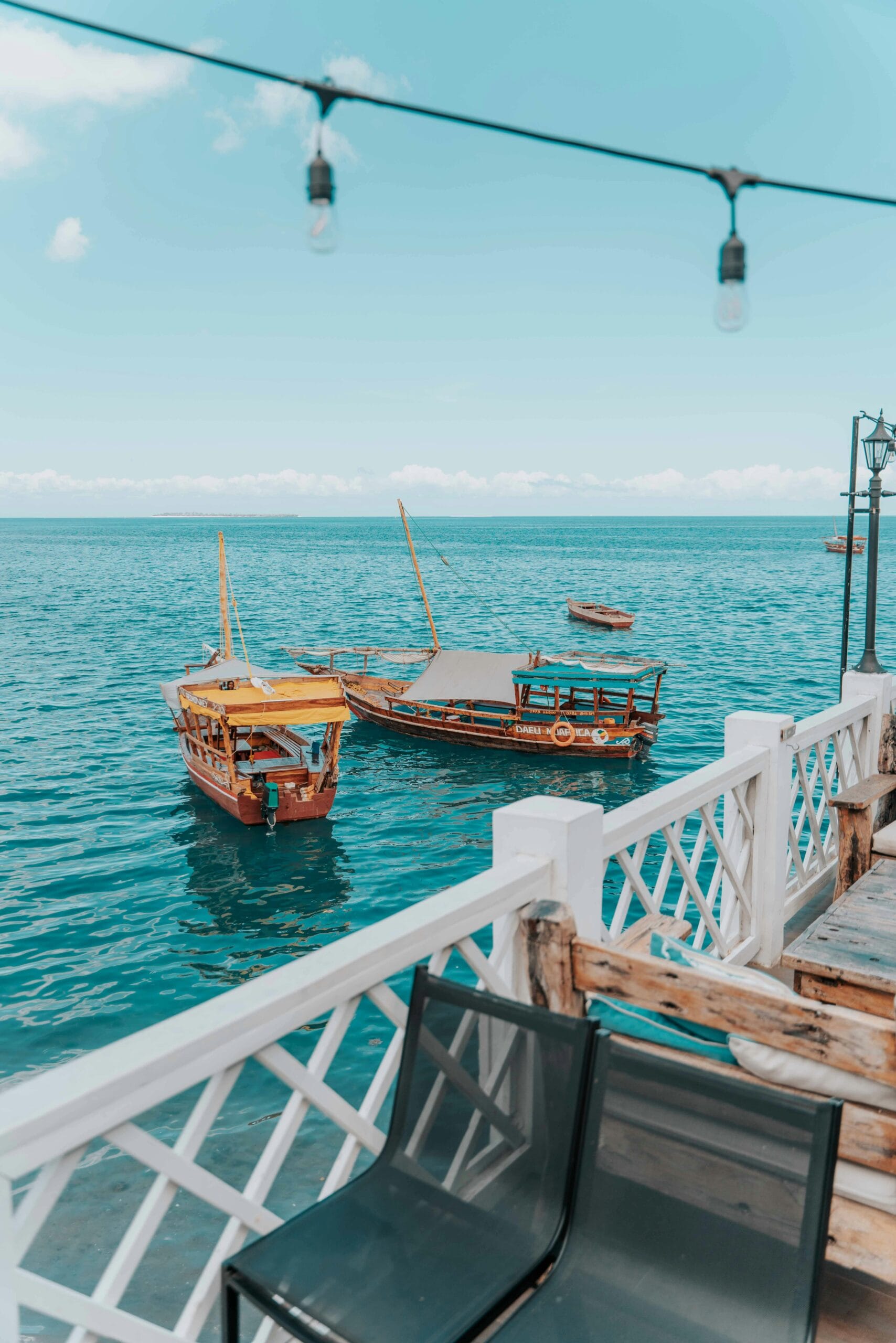 How to get to Zanzibar from Dar es Salaam 1 Traditional dhow boats float peacefully on the turquoise waters of Zanzibar, Tanzania.