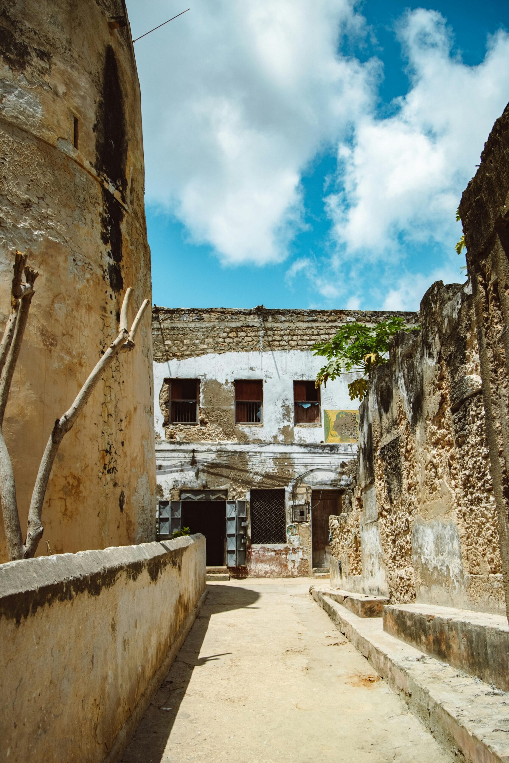 Explore the Ruins of Zanzibar with Safari Packages 1 Explore the timeless architecture and charm of an ancient narrow alley in a historic old town under a clear blue sky.