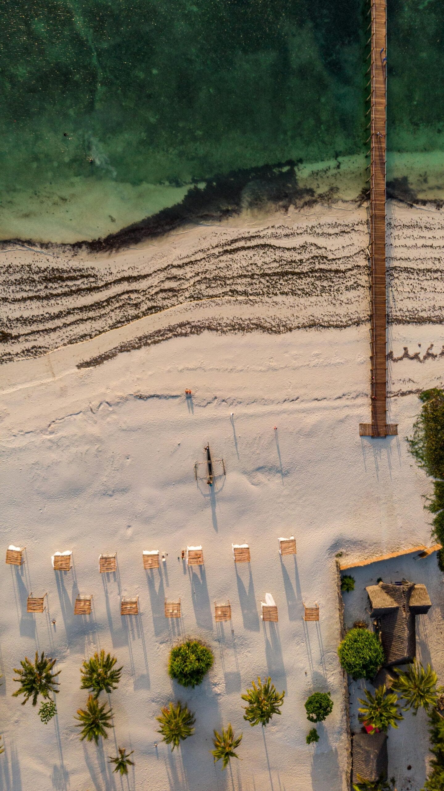 7-Day Safari and Zanzibar Luxury Escape for Honeymooners: A Perfect Romantic Getaway 1 Stunning aerial shot of a pristine beach and pier in Zanzibar, Tanzania.
