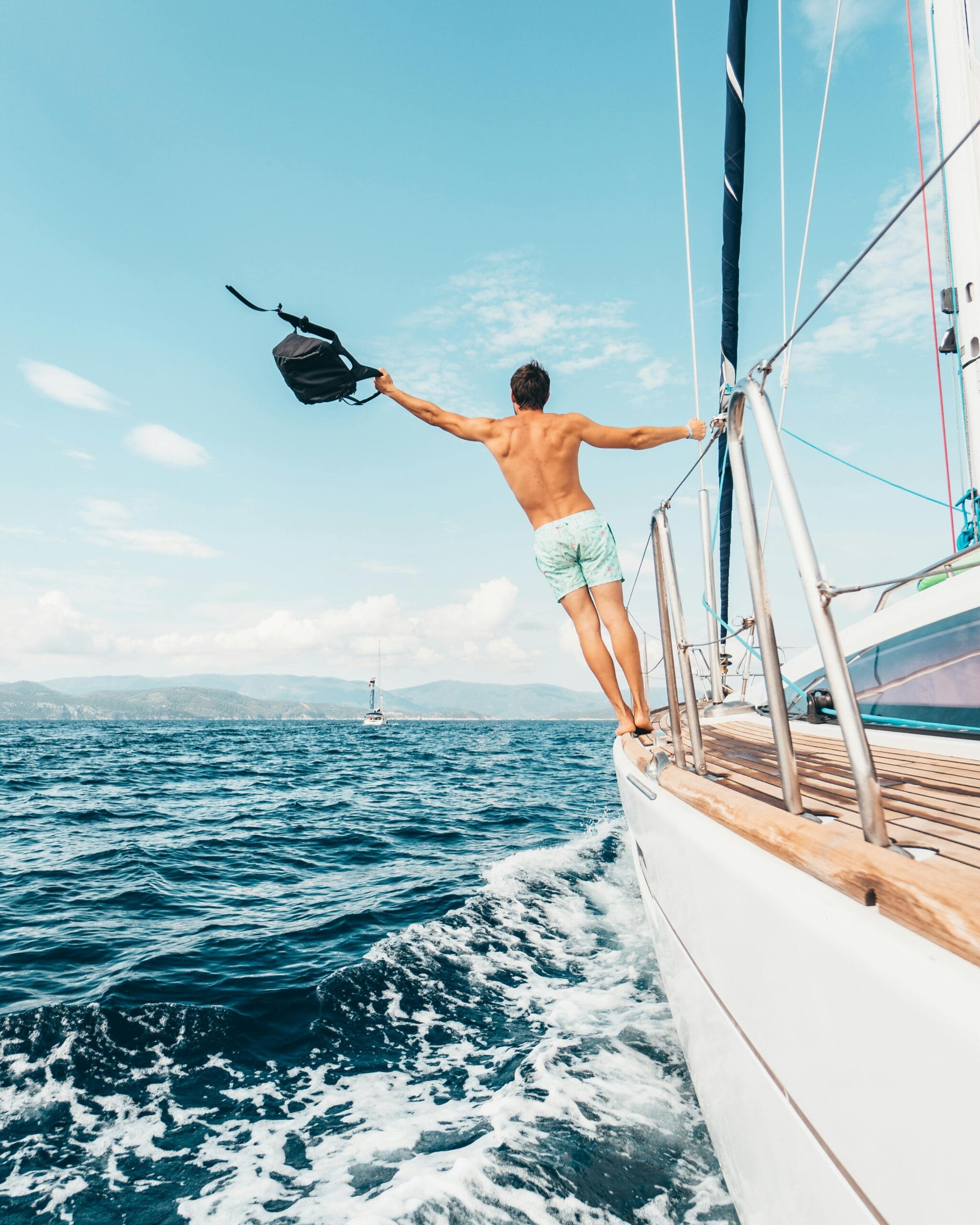 Unforgettable Safari Memories with Expert Guides: Experience Tanzania Like Never Before 1 Man enjoying freedom by jumping into the ocean from a sailboat in Greece.