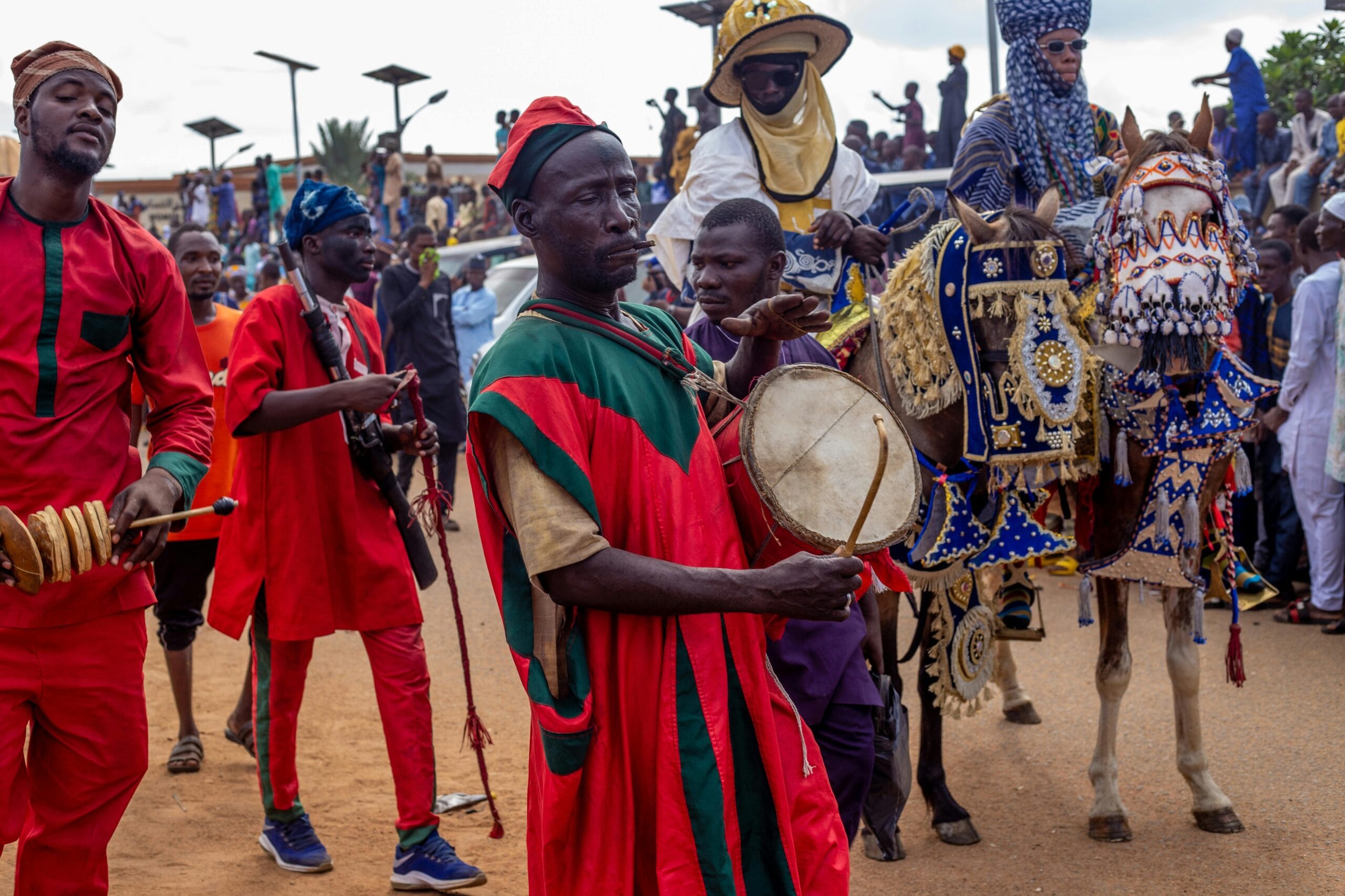 Colorful parade showcasing traditional African costumes, music, and decorated horses during a cultural festival.