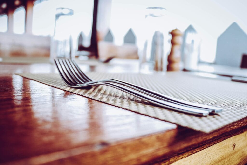 A close-up view of a neatly set dining table in a Zanzibar City restaurant, featuring sleek forks on a stylish mat.