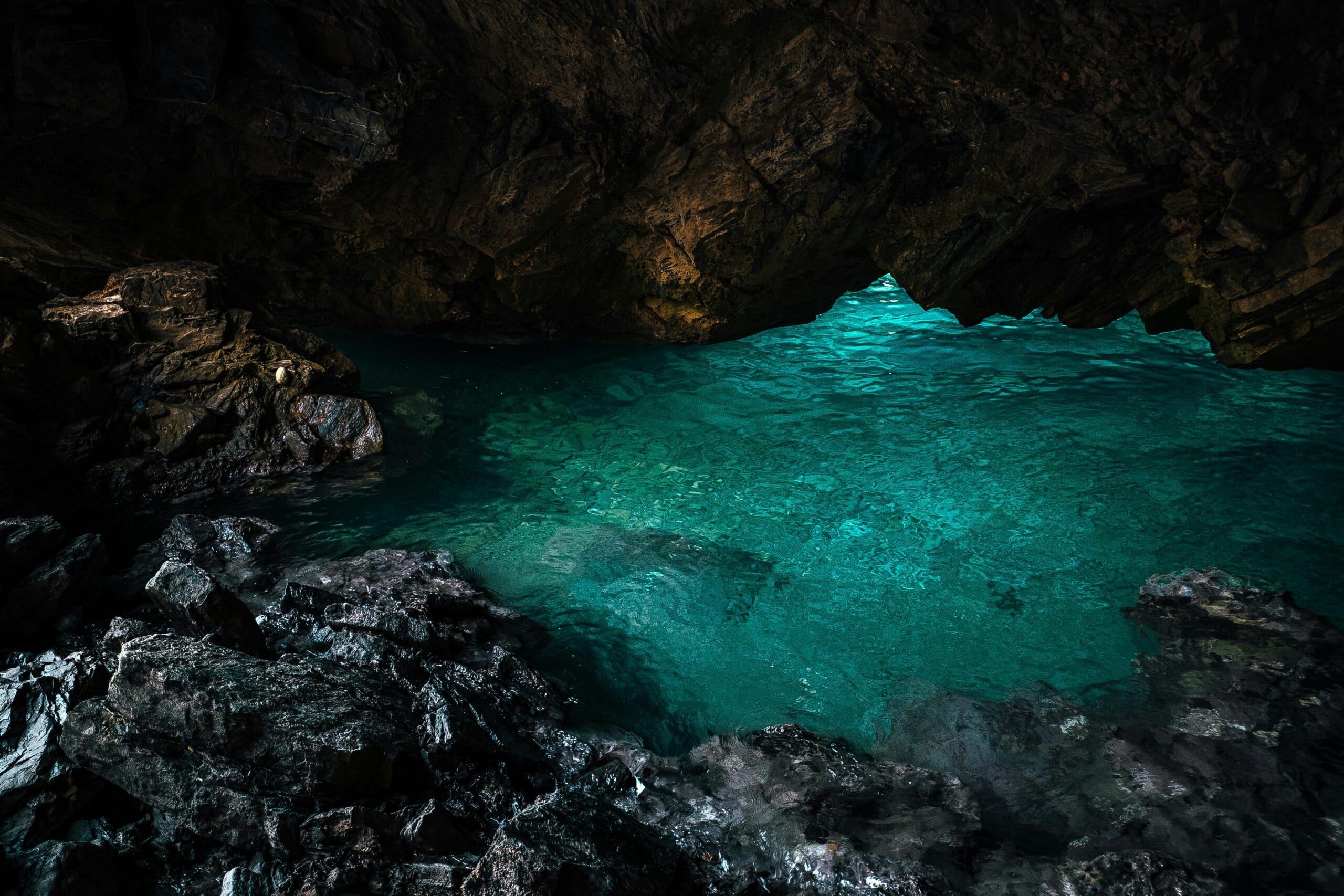 Explore the serene blue waters within a stunning geological cave formation.