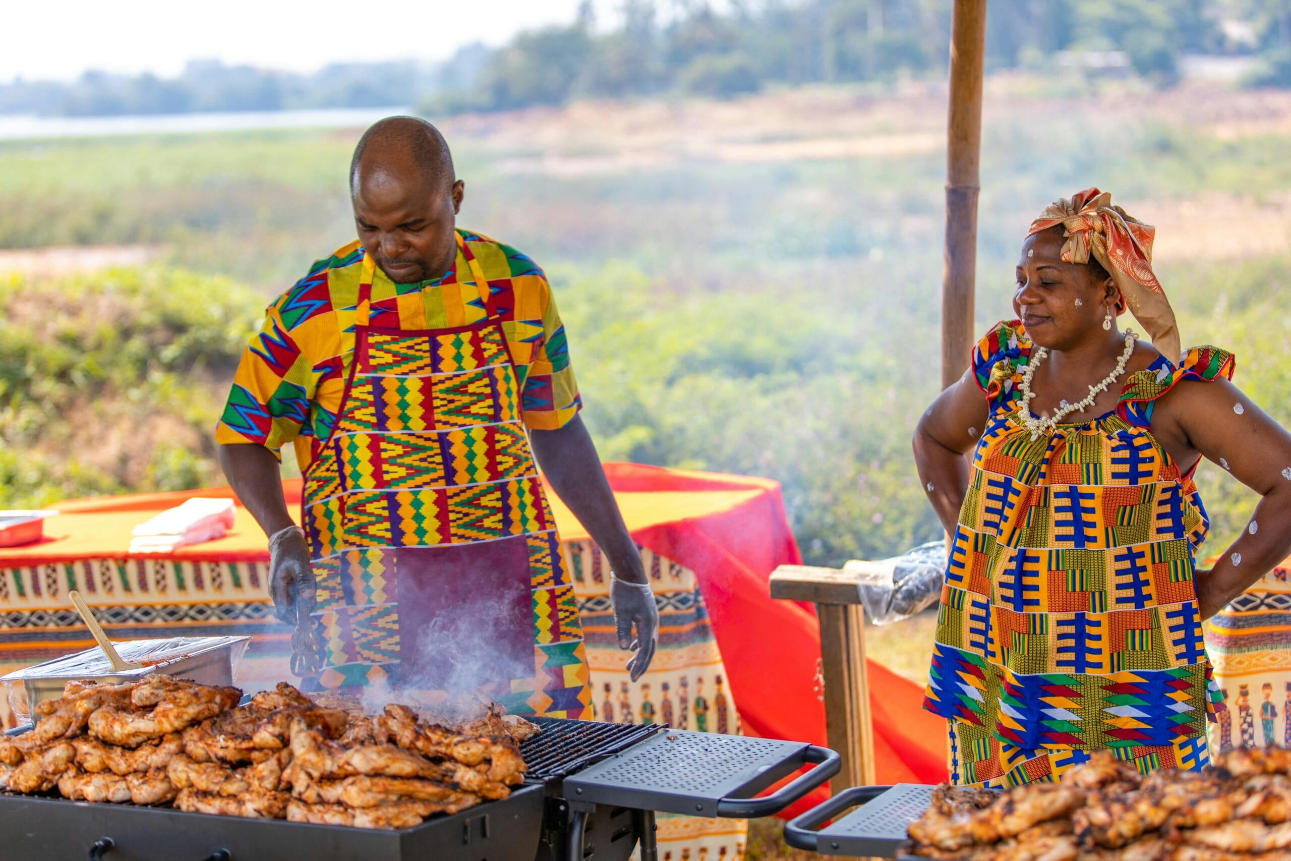 Festive outdoor grill featuring colorful traditional African attire.