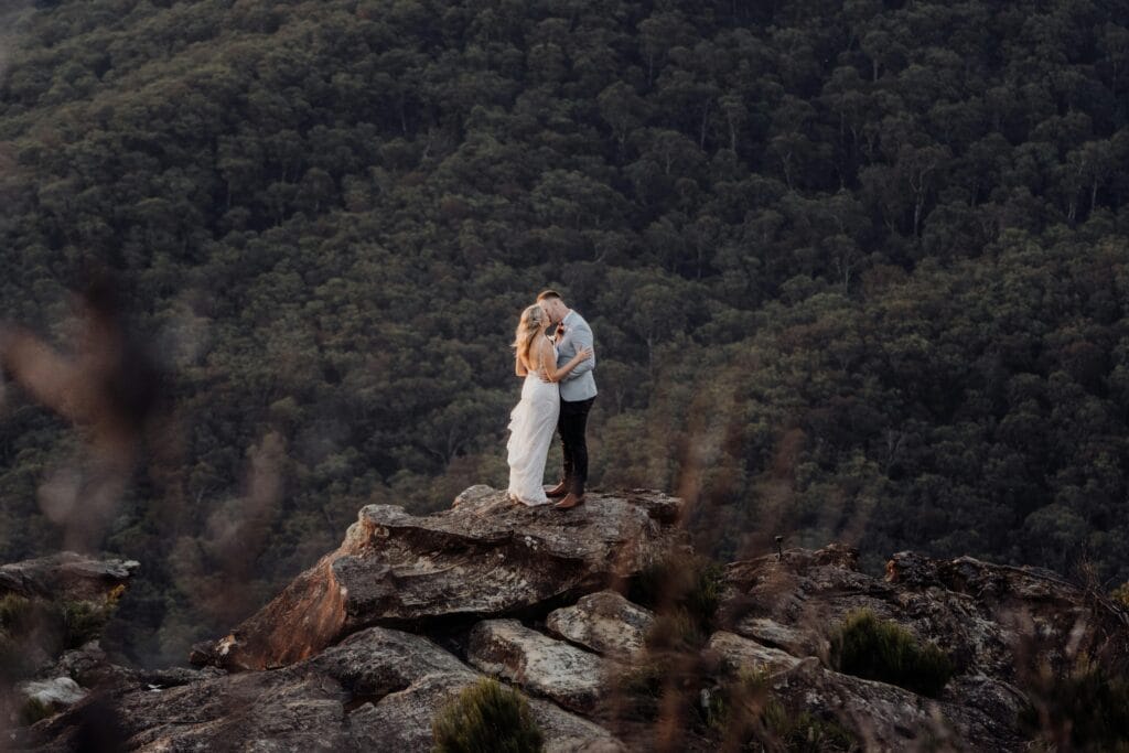 Safari Planning for Seniors: A Guide to a Comfortable and Memorable Adventure 1 A couple embraces on a rocky outcrop amidst the scenic Blue Mountains, NSW, Australia.