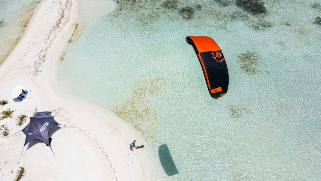 The best time for kite surfing in Zanzibar 8 A breathtaking aerial view of kiteboarding along a clear coastal shoreline, perfect for adventure sports enthusiasts.