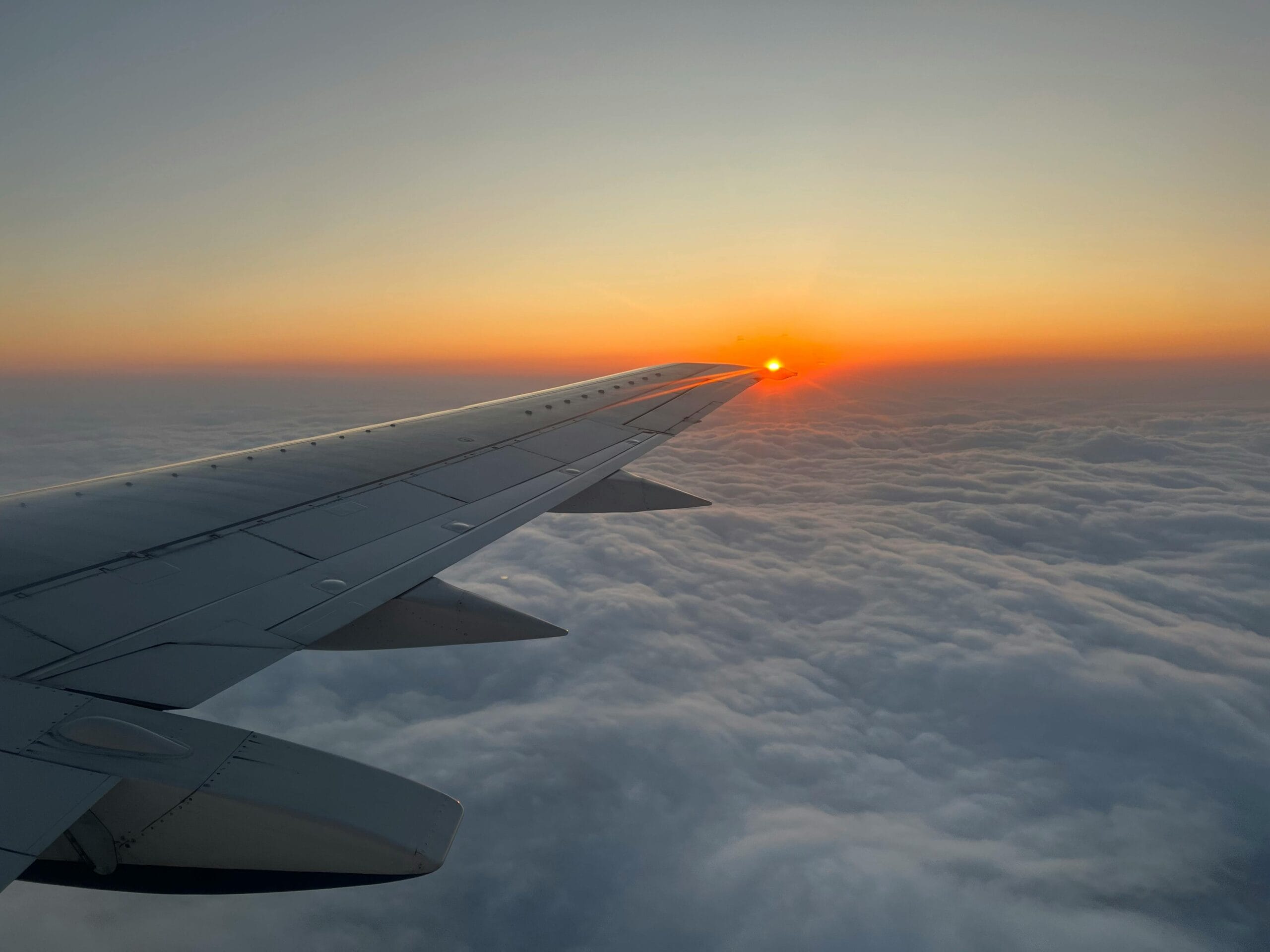 Captivating view from an airplane wing at sunrise over a cloud-filled sky in South Africa.