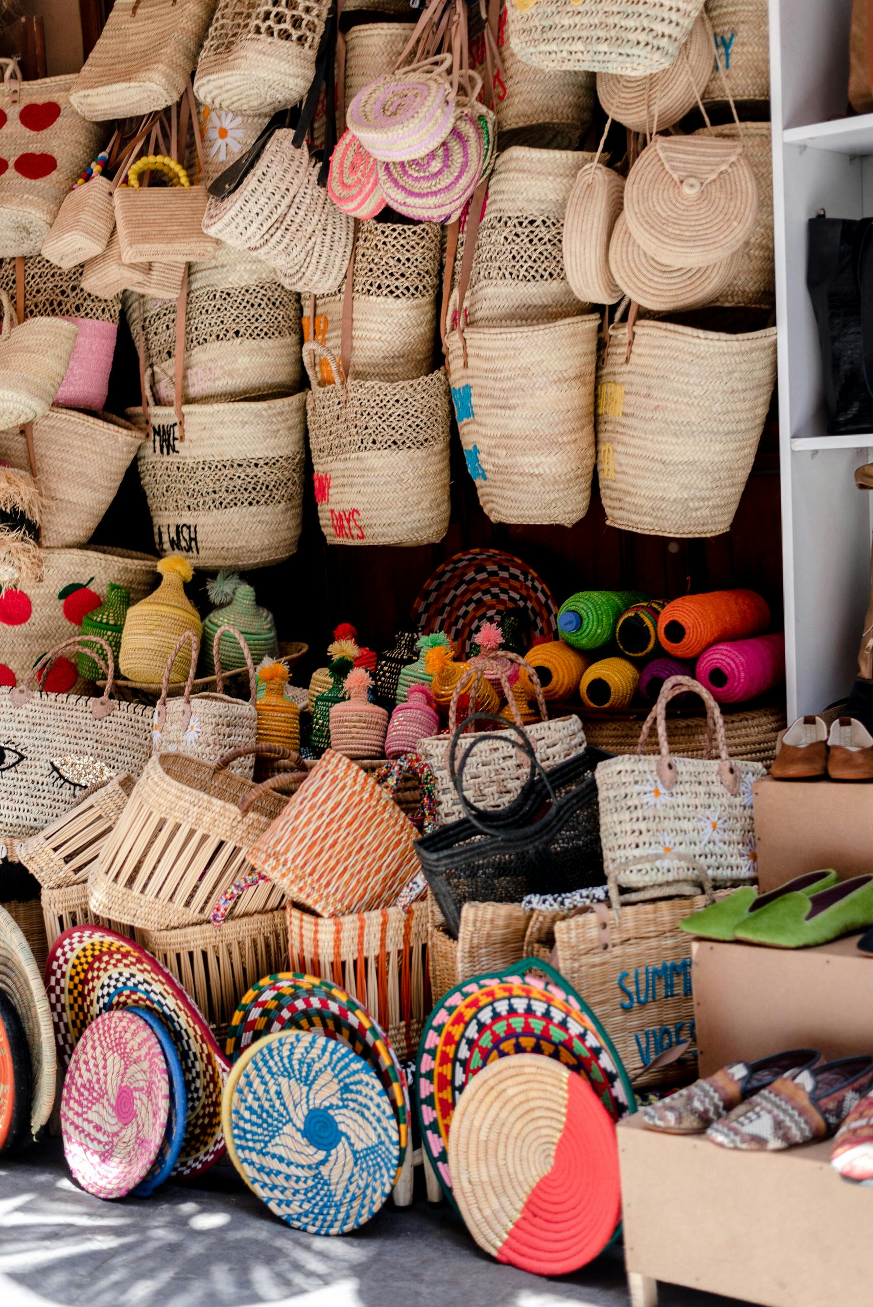 Supporting Local Tanzanian Artisans: Empowering Communities Through Craft 1 Vibrant display of handmade wicker bags and baskets at a Marrakech market, showcasing Moroccan craftsmanship.