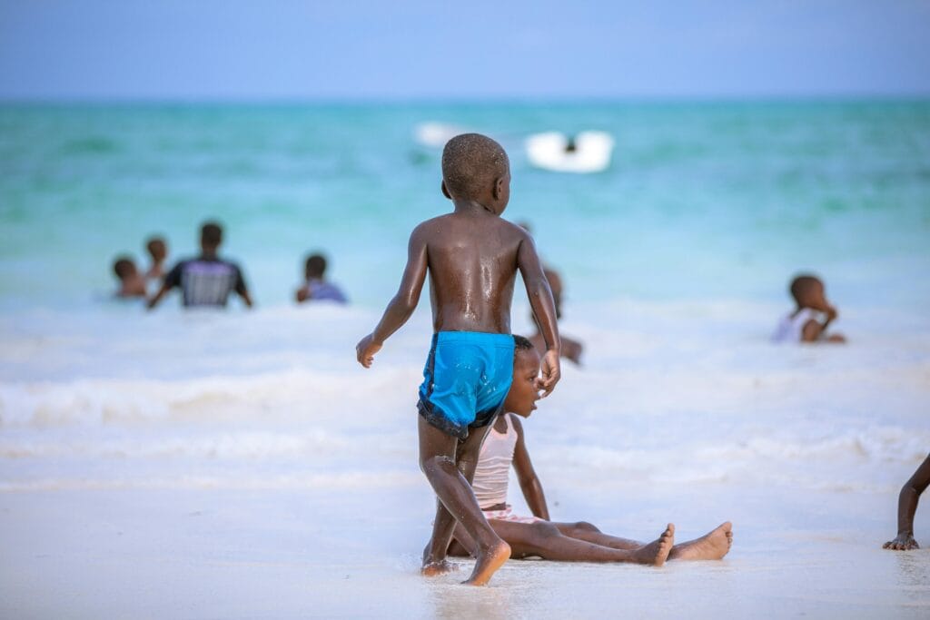 Joyful children playing on a sunny beach in Zanzibar, Tanzania.