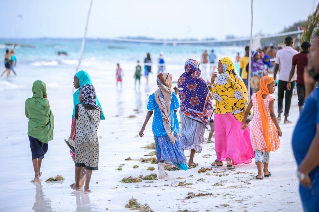 Women in vibrant clothing enjoying a seaside walk in Unguja South Region, Tanzania.