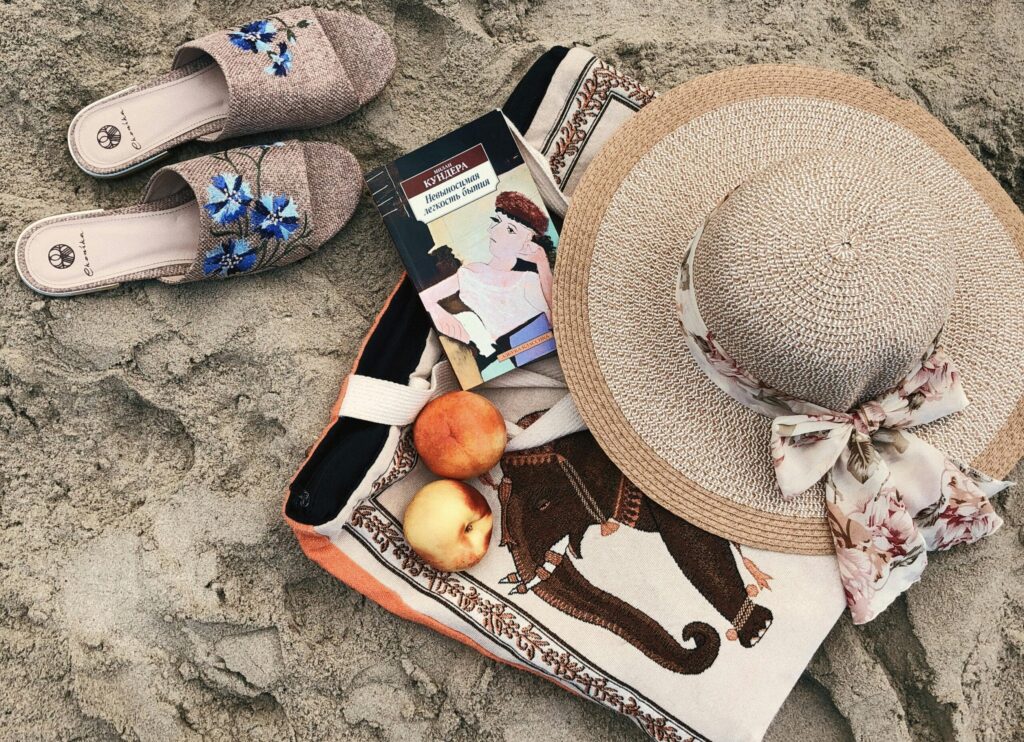 How to book last-minute trips to Zanzibar 4 Flat lay of beach essentials with hat and slippers on sand. Perfect summer vibe.