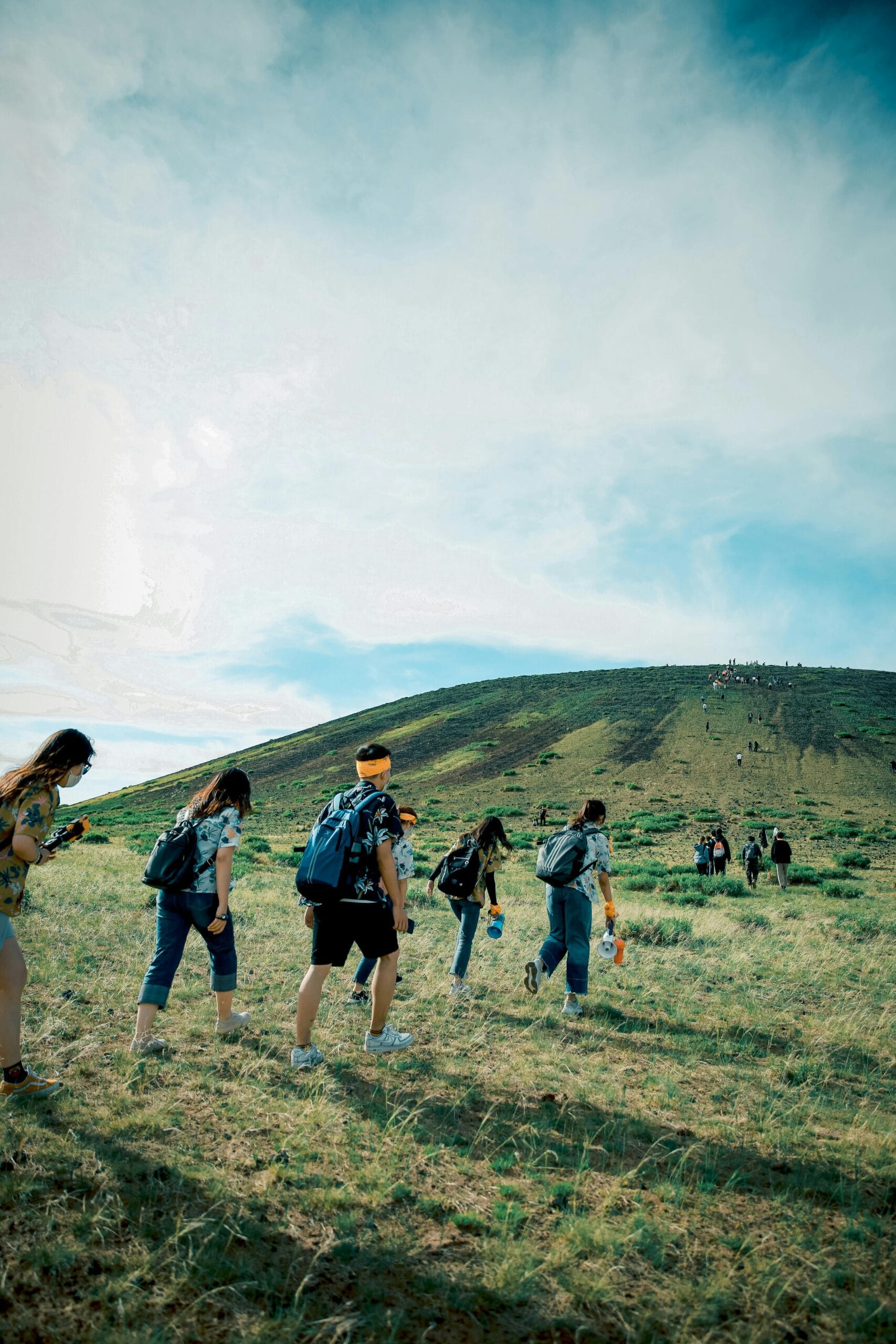 6-Day Adventure Safari for Nature Enthusiasts 1 A group of hikers ascending a scenic hillside under a bright blue sky, perfect for adventure and travel themes.
