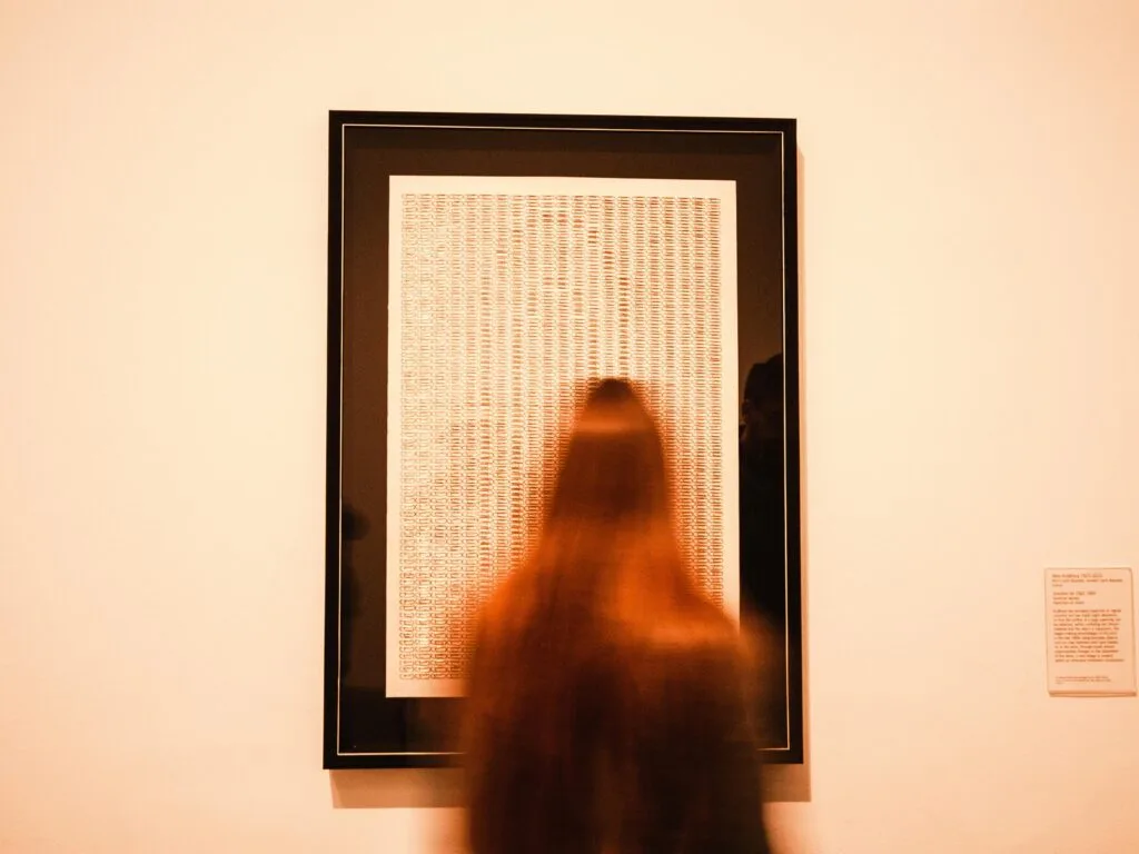 Must-visit galleries and art shops in Zanzibar 16 A blurred figure views artwork in a London museum, emphasizing artistic interpretation.