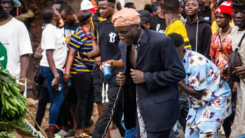 Lively street parade with energetic participants in colorful attire, showcasing African culture.