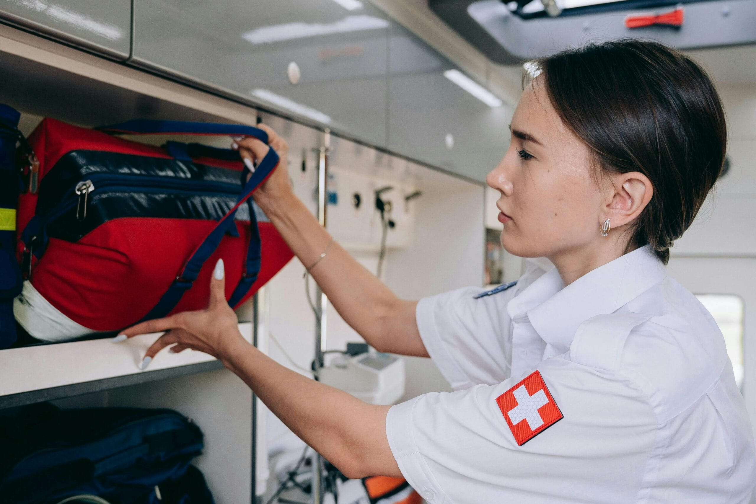 Paramedic organizes medical equipment in ambulance, ensuring readiness for emergencies.