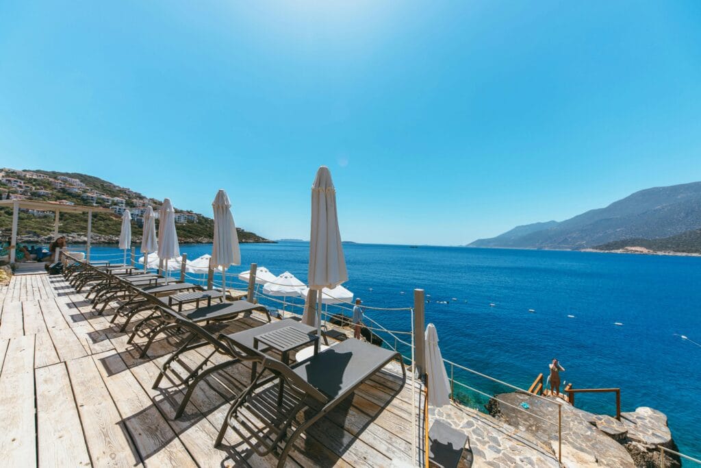 Scenic view of beach lounge chairs and umbrellas facing a serene blue sea on a sunny day.
