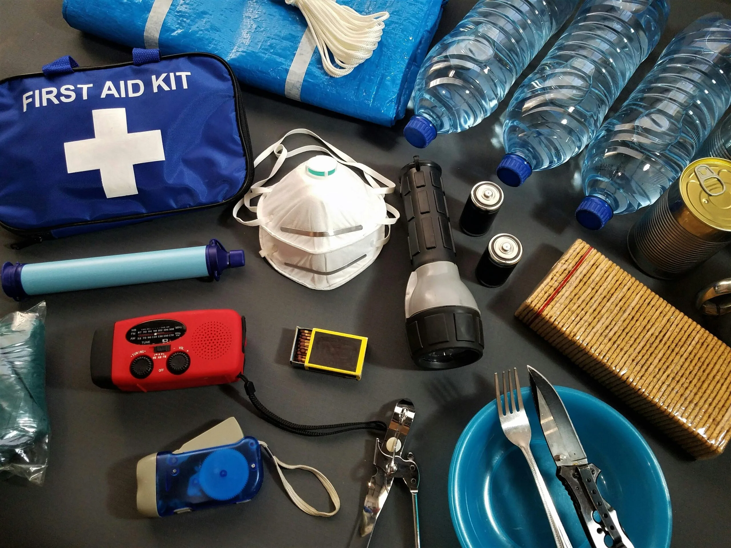 How to Deal with Motion Sickness on Safari 1 Flat lay of essential emergency survival kit items including first aid and water bottles.