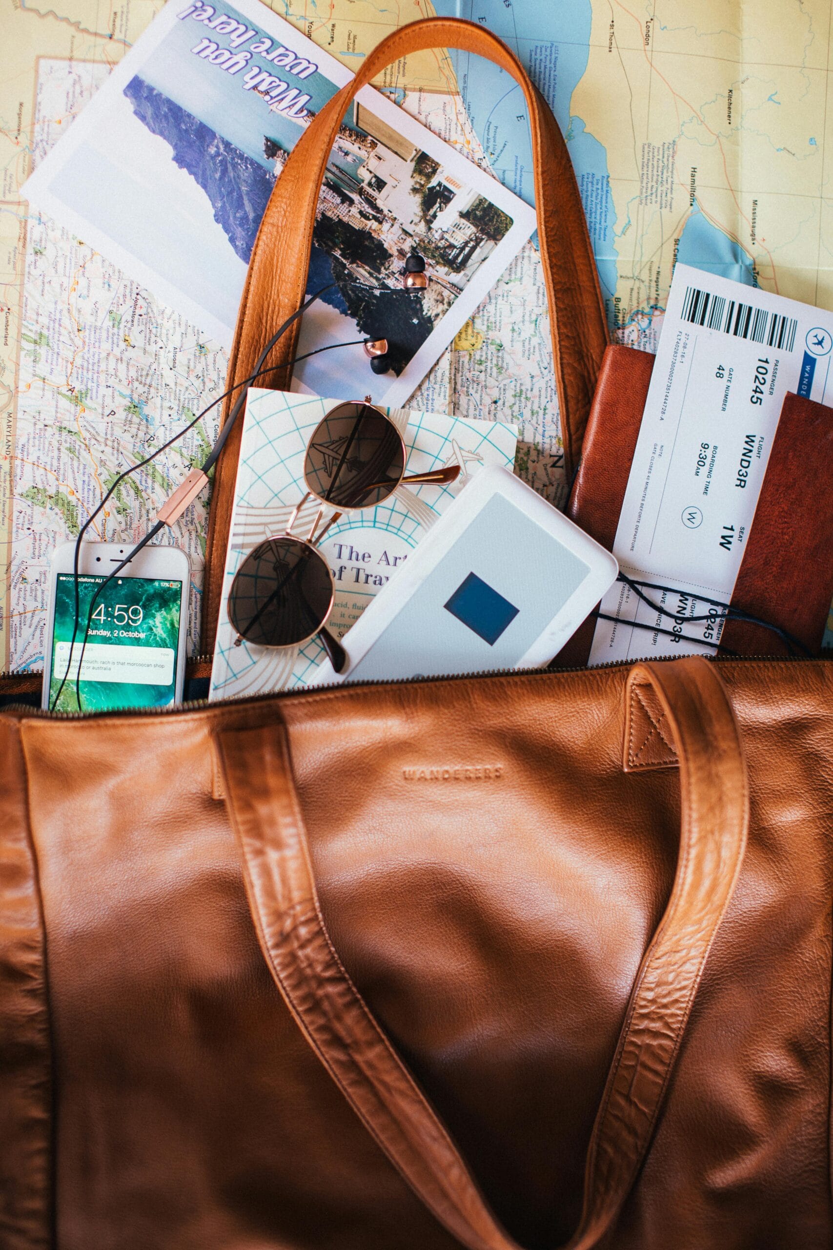 Safari Packing Guide for Your Trip 1 Flat lay of travel essentials including a leather bag, map, sunglasses, and tickets.