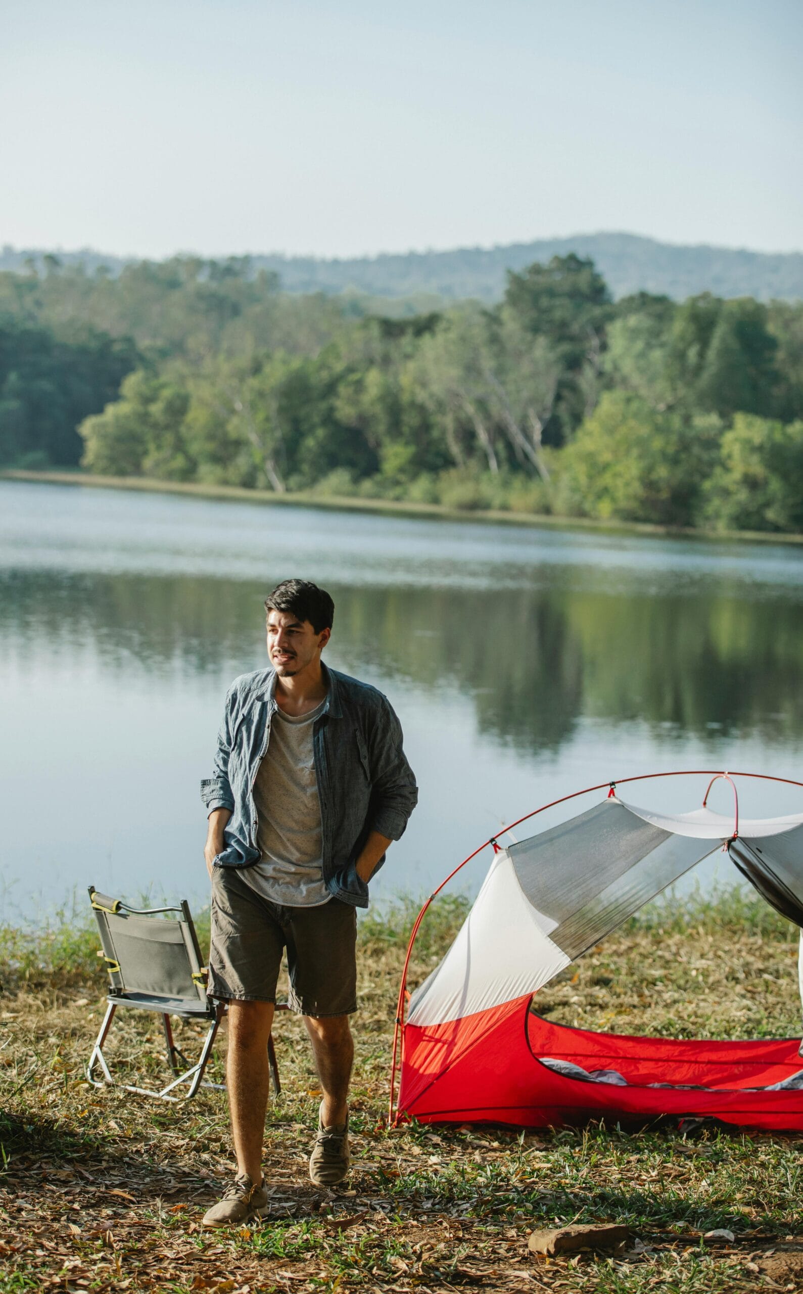 2-Day Camping Safari: Wildlife on a Budget 1 Adult male traveler with hands in pockets strolling on lake shore while looking away against trees