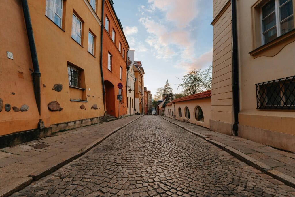 Explore a peaceful, colorful cobblestone street lined with historic architecture in a European town.
