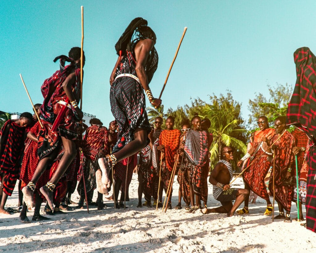 When to Visit Tanzania for Festivals: A Guide to Year-Round Cultural Celebrations 5 A captivating scene of Maasai warriors performing a traditional jumping dance on Nungwi Beach, Tanzania.