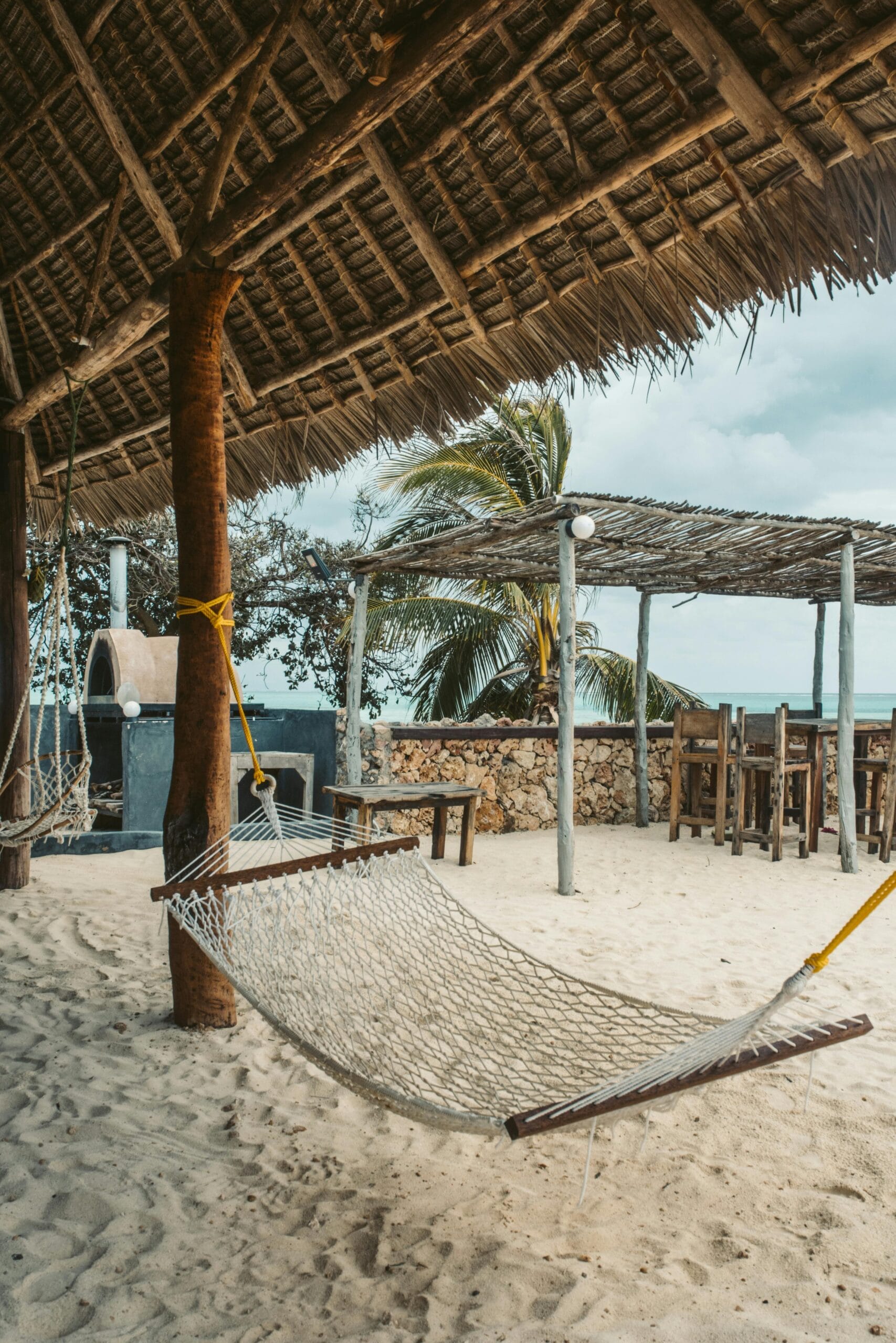 15 Days Tanzania Honeymoon Safari & Zanzibar Vacation 13 Relax in a hammock under palm leaves on a Zanzibar beach, perfect for a tropical vacation.