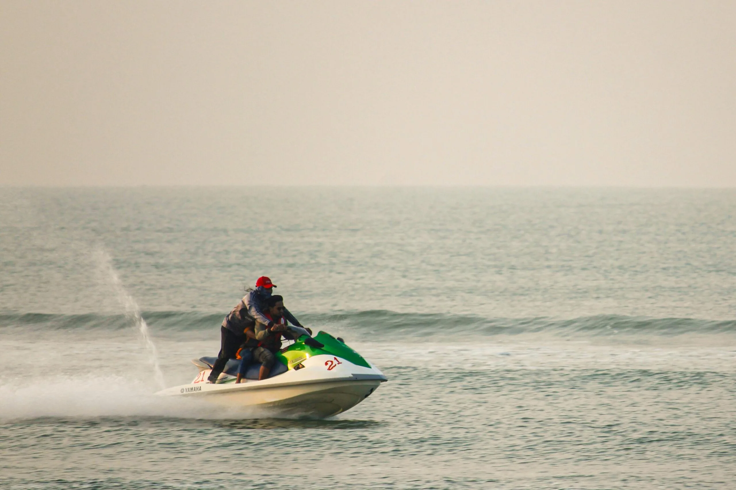 Zanzibar 3 People enjoying a thrilling jet ski ride on a calm ocean day.